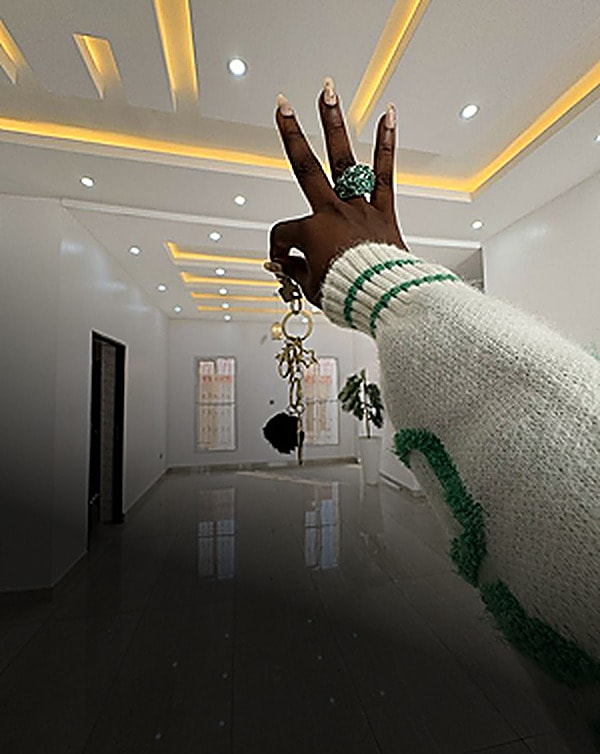 Hand holding up new house keys in an empty room